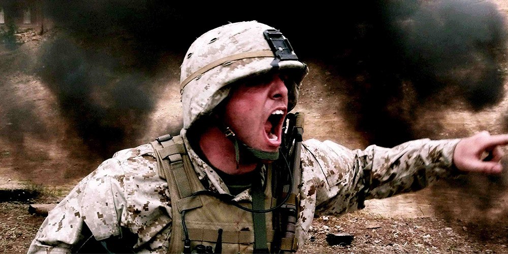 Soldier shouting orders in combat, surrounded by smoke