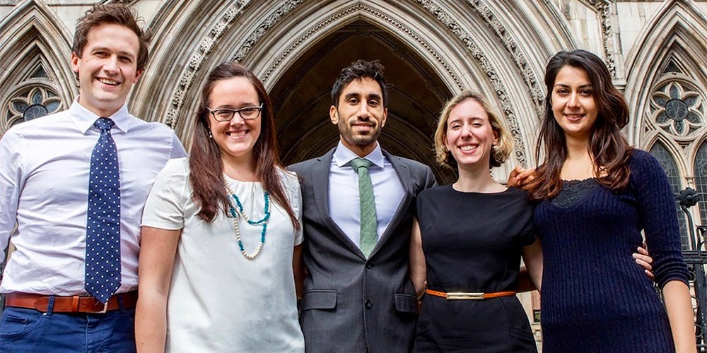 Five Junior Doctors standing in a row in front of the Royal Courts of Justice