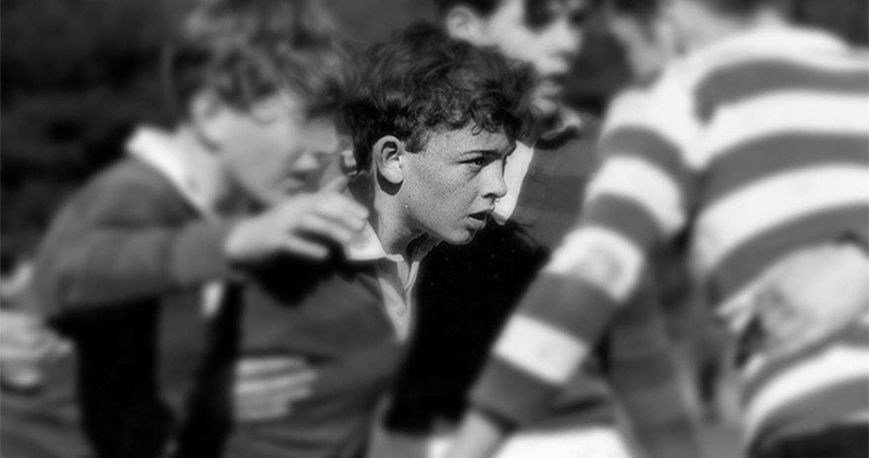 Black and white picture of children playing rugby in the 1970s